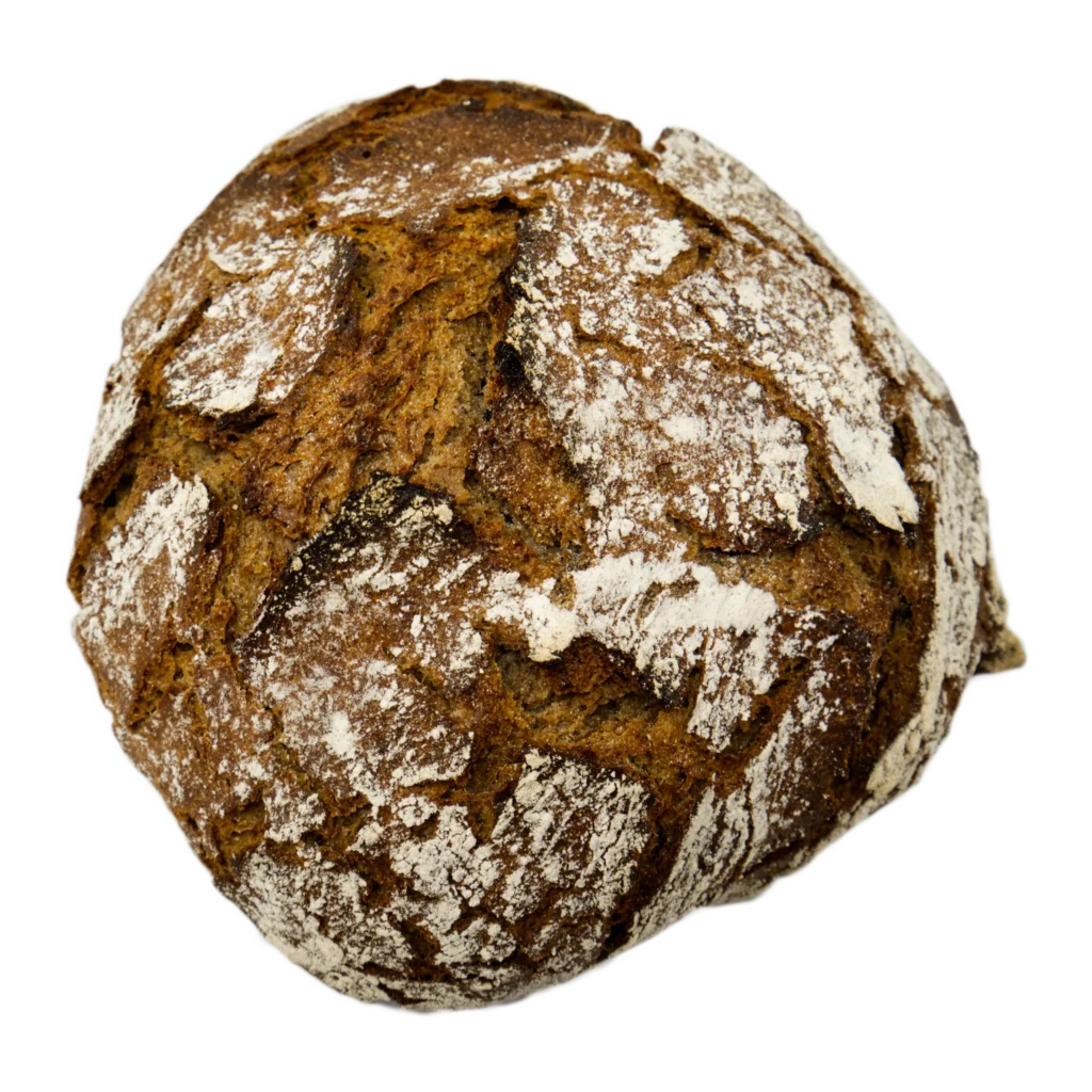 Ein runder, rustikaler Brotlaib mit einer dunklen, knusprigen Außenseite und Flecken von weißem Mehl auf der Oberfläche, vor einem schlichten Hintergrund.